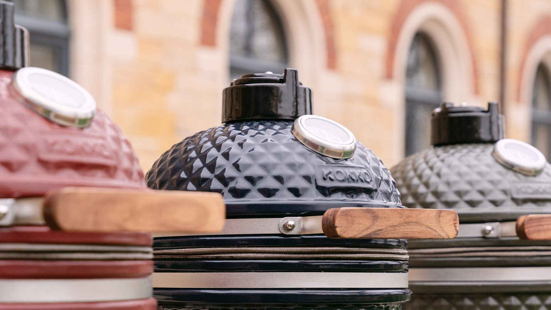 Trois kamados de différentes couleurs posés côte à côte, comparatif de barbecues en céramique polyvalents pour cuisson extérieure