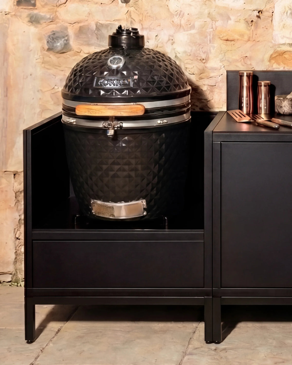 Kamado em cerâmica preto Kokko instalado no módulo PILOTIS com acessórios em cobre, cozinha exterior