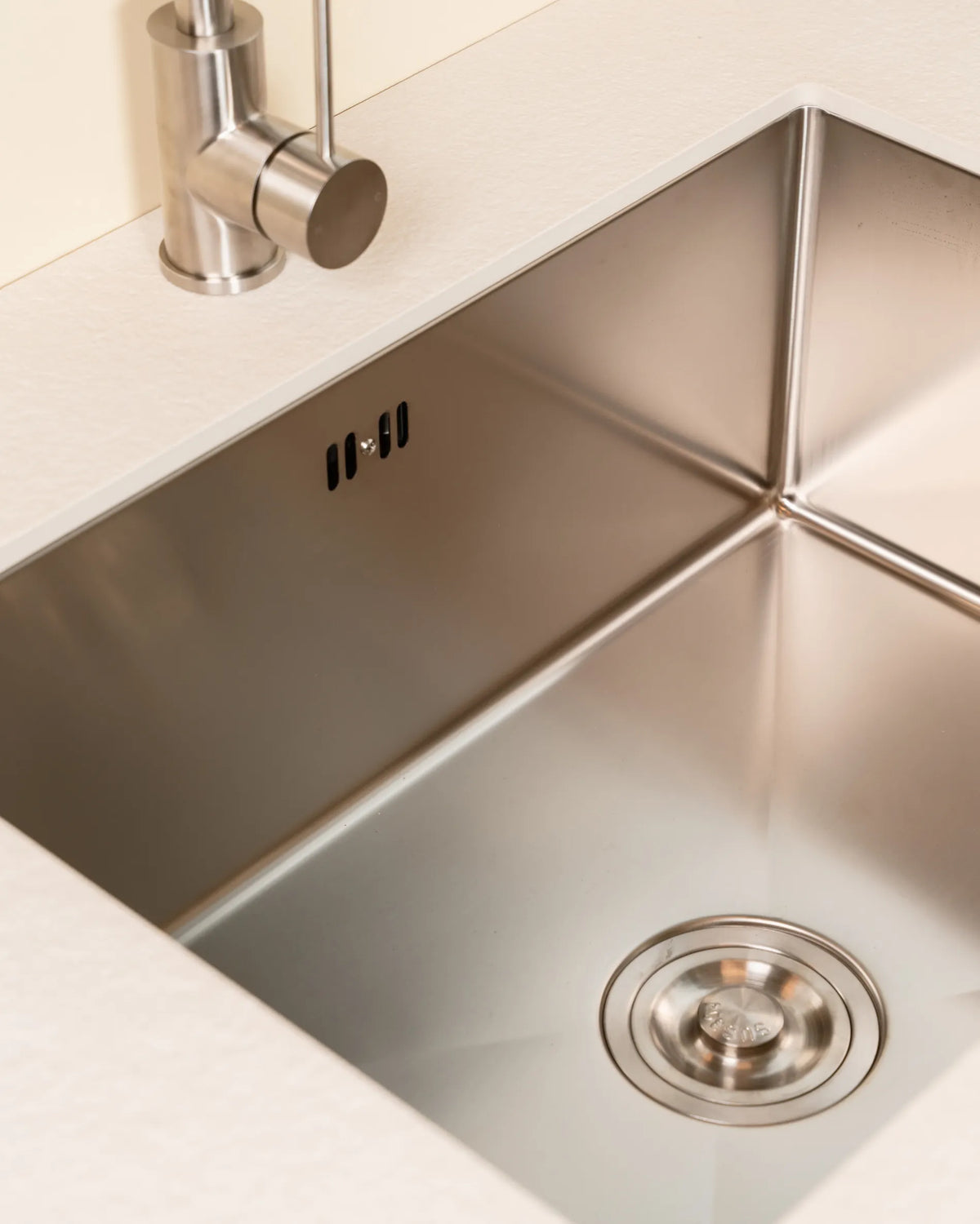 Cuba em inox do módulo de Lavatório PILOTIS embutida no tampo bege creme, vista em detalhe