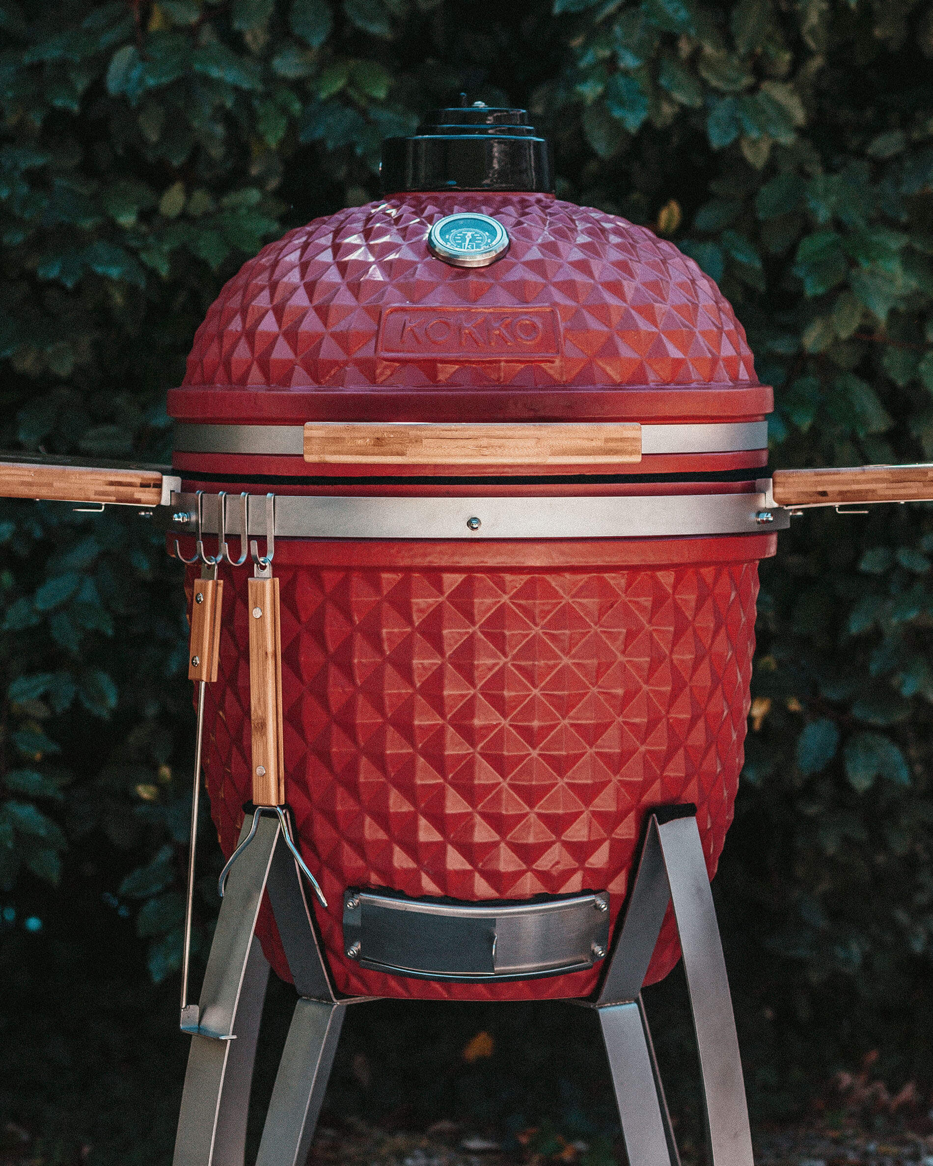 Kamado Kokko vermelho equipado com ganchos para acessórios.