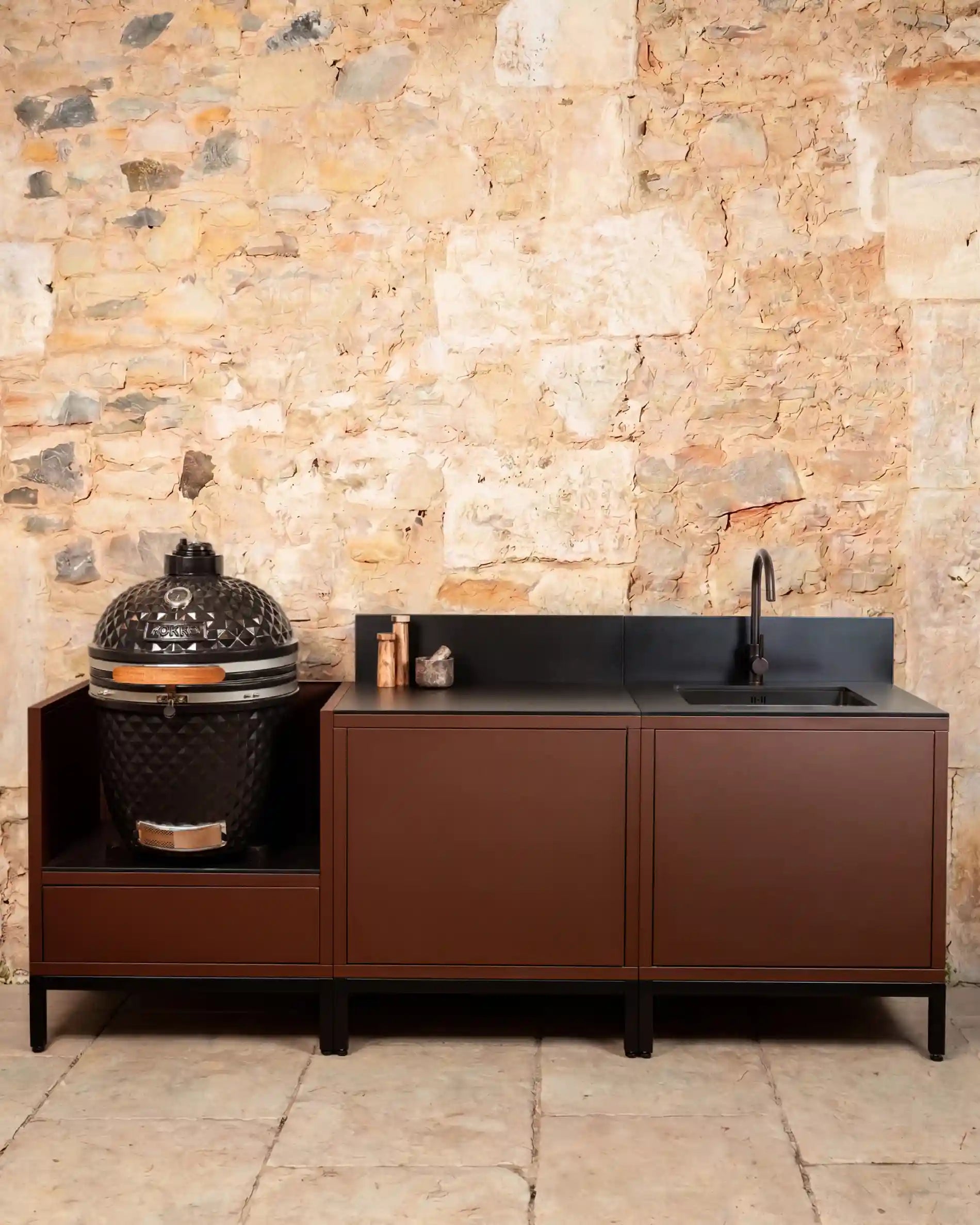 Cozinha exterior Kokko Pilotis rust com bancada preta e kamado