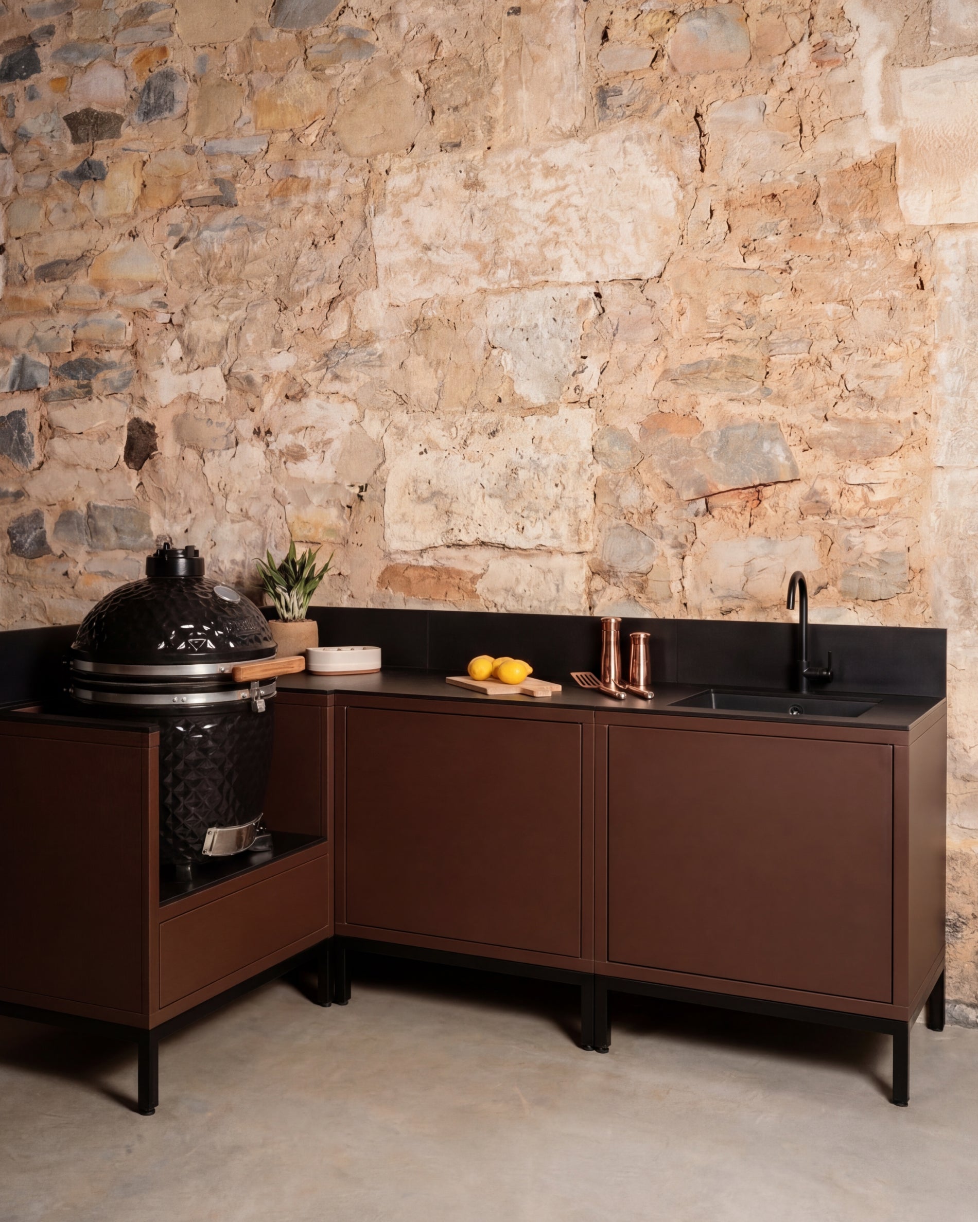 Cozinha exterior Kokko Pilotis em ângulo cor rust com lava-loiça e kamado integrado