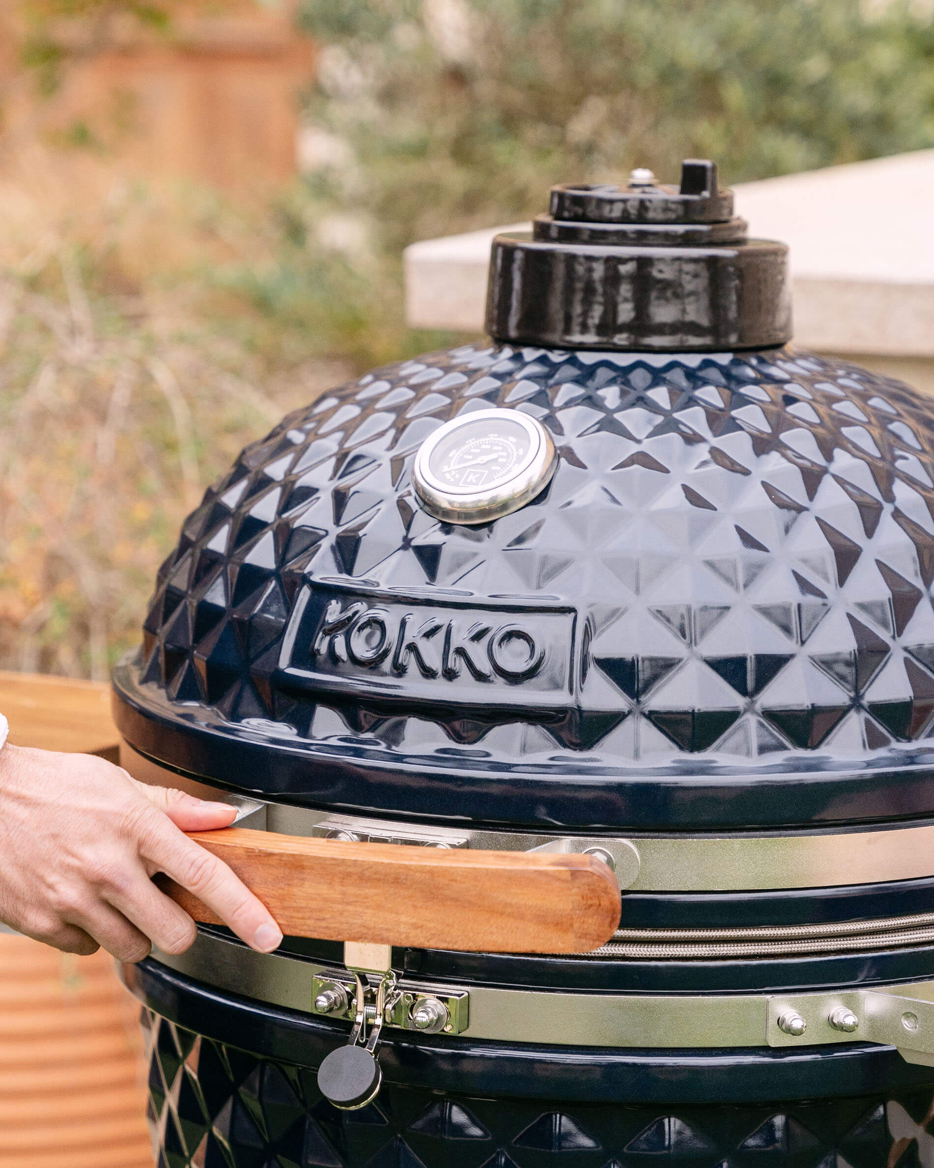 Close-up da tampa de um kamado Kokko XL 22 polegadas em cerâmica azul-marinho.
