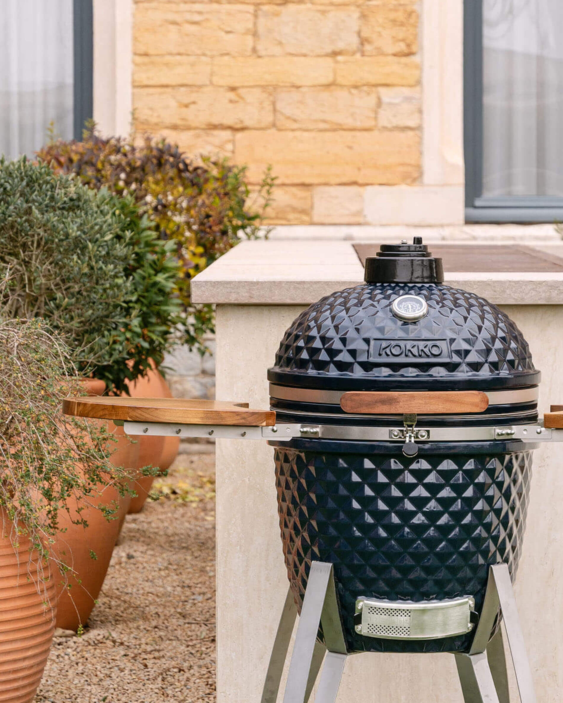 Kamado Kokko 22 polegadas cor navy, apresentado sozinho no exterior.