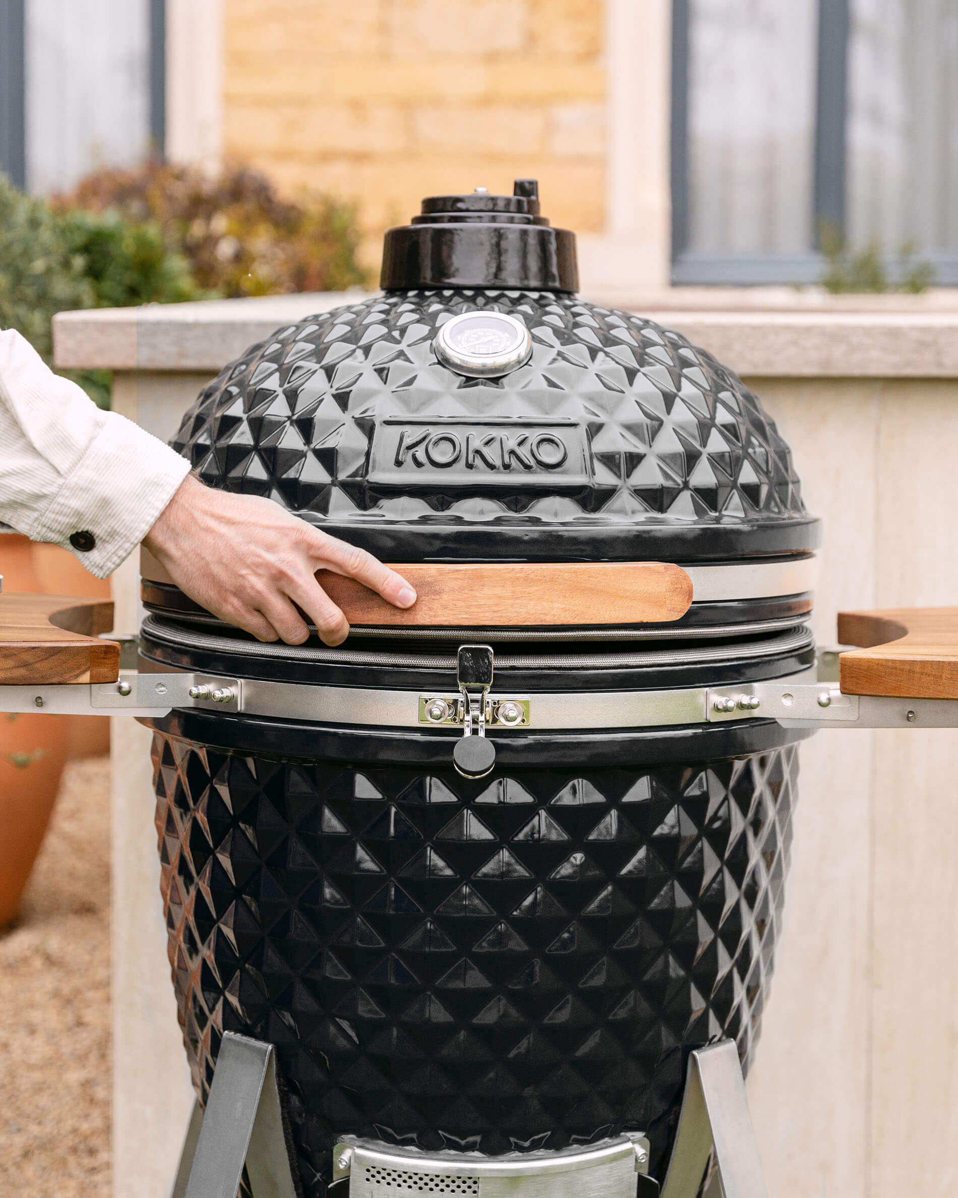 Kamado Kokko XL 22 polegadas em cerâmica preta instalado no exterior.