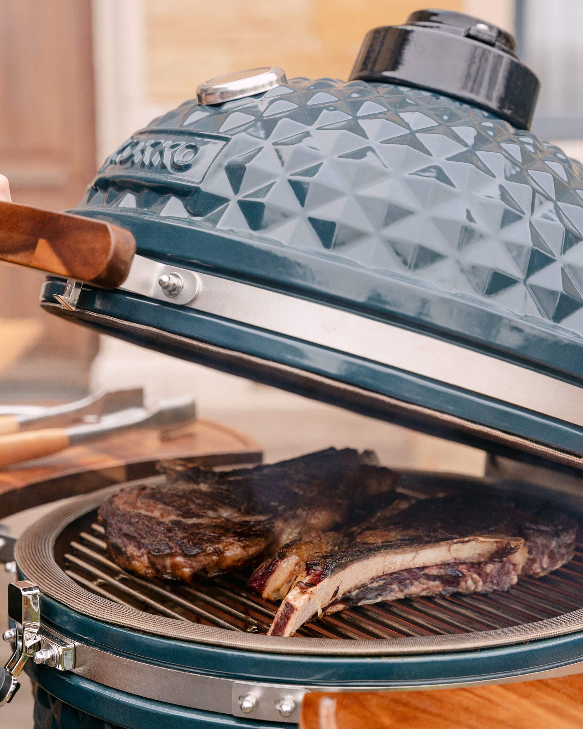 Detalhe da tampa de um kamado Kokko XL 22 polegadas em cerâmica azul oceano.