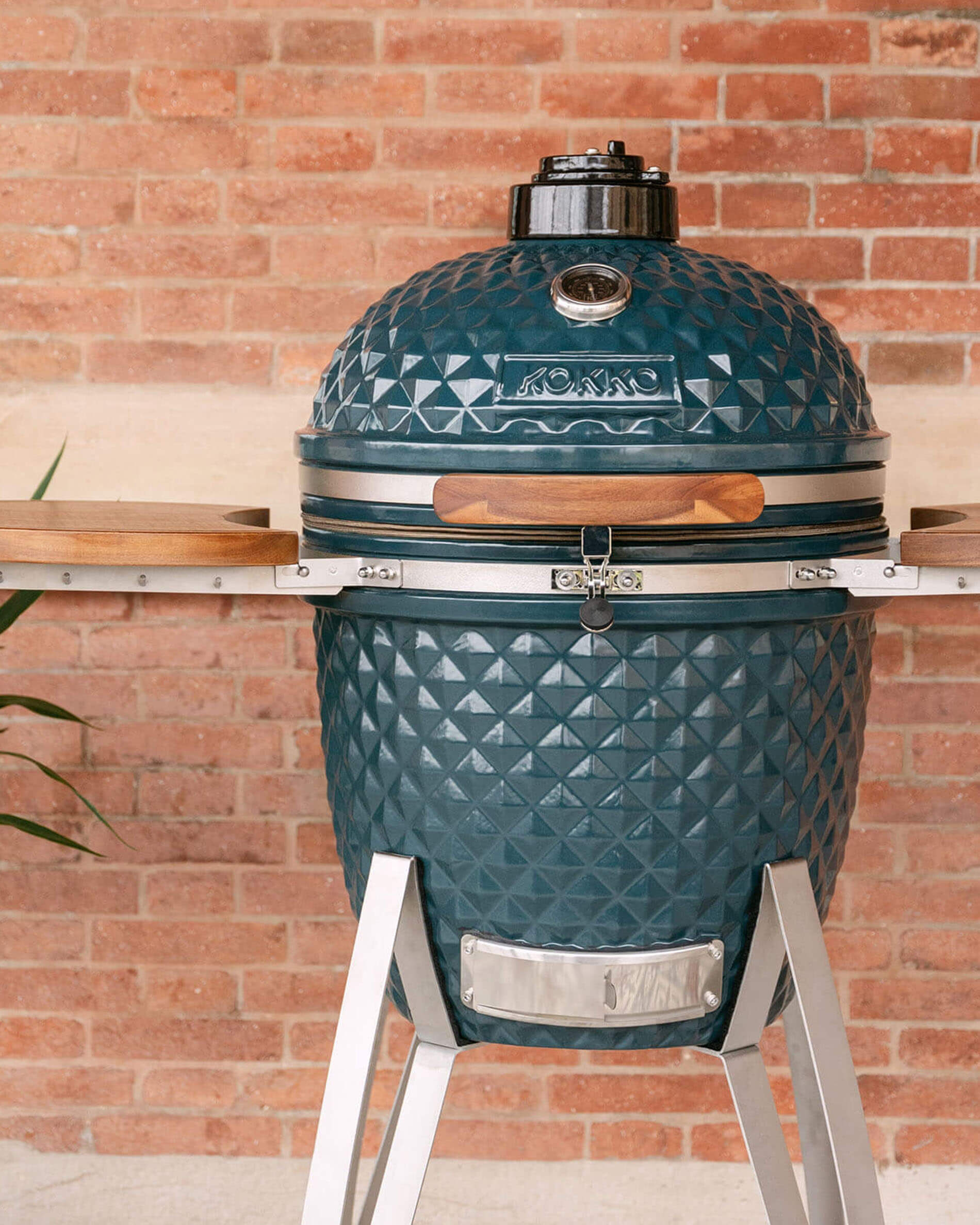 Kamado Kokko 22 polegadas cor oceano, apresentado sozinho no exterior.