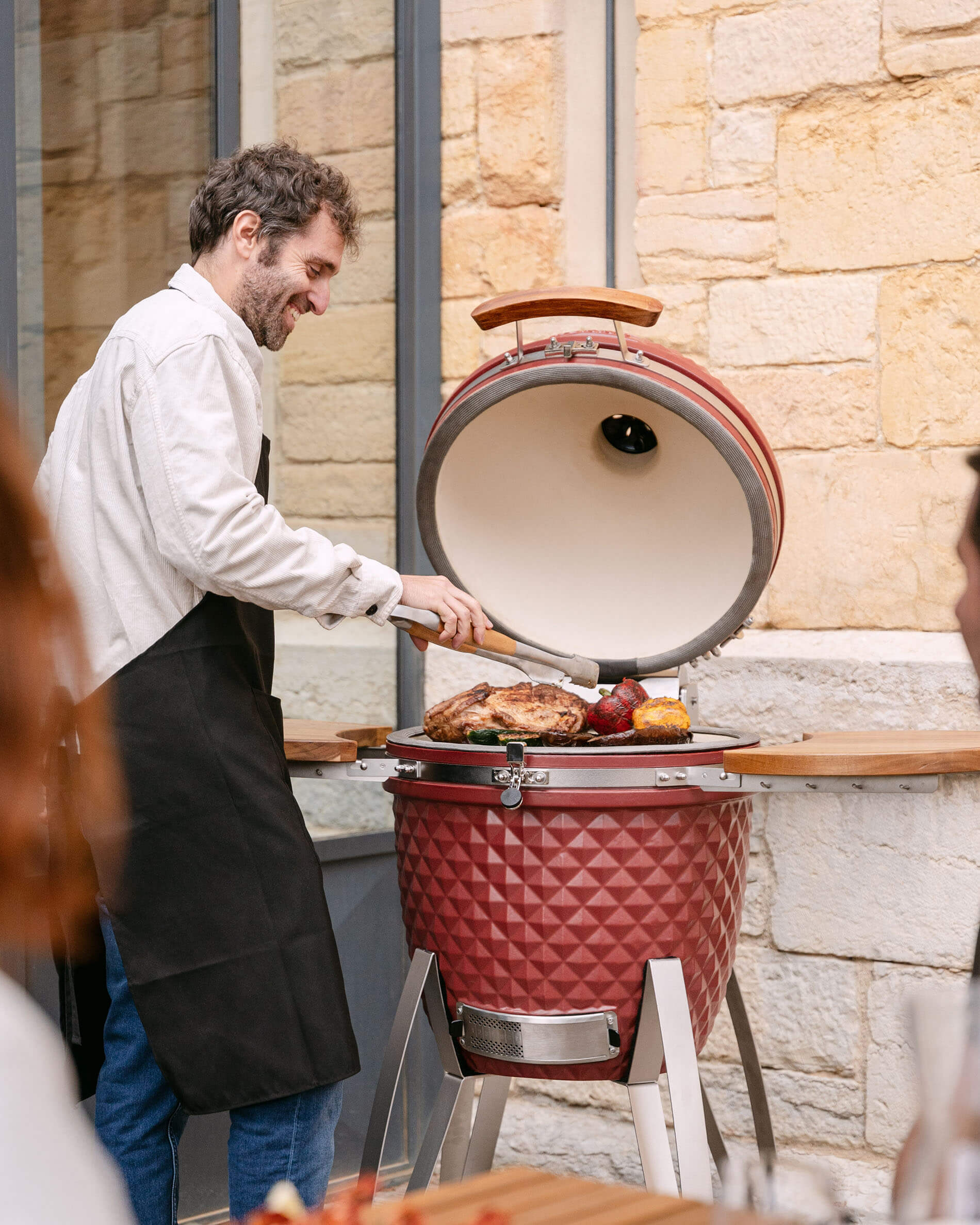 Kamado Kokko em cerâmica vermelho óxido em utilização durante a confeção.