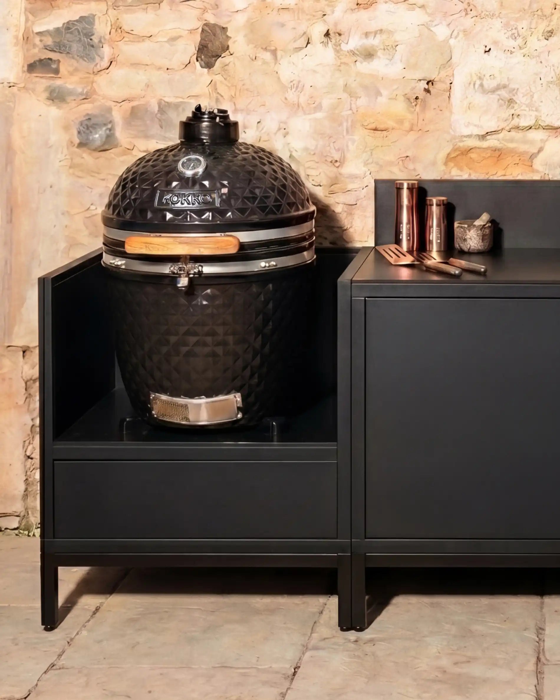 Kamado Kokko preto integrado numa cozinha exterior com arrumação