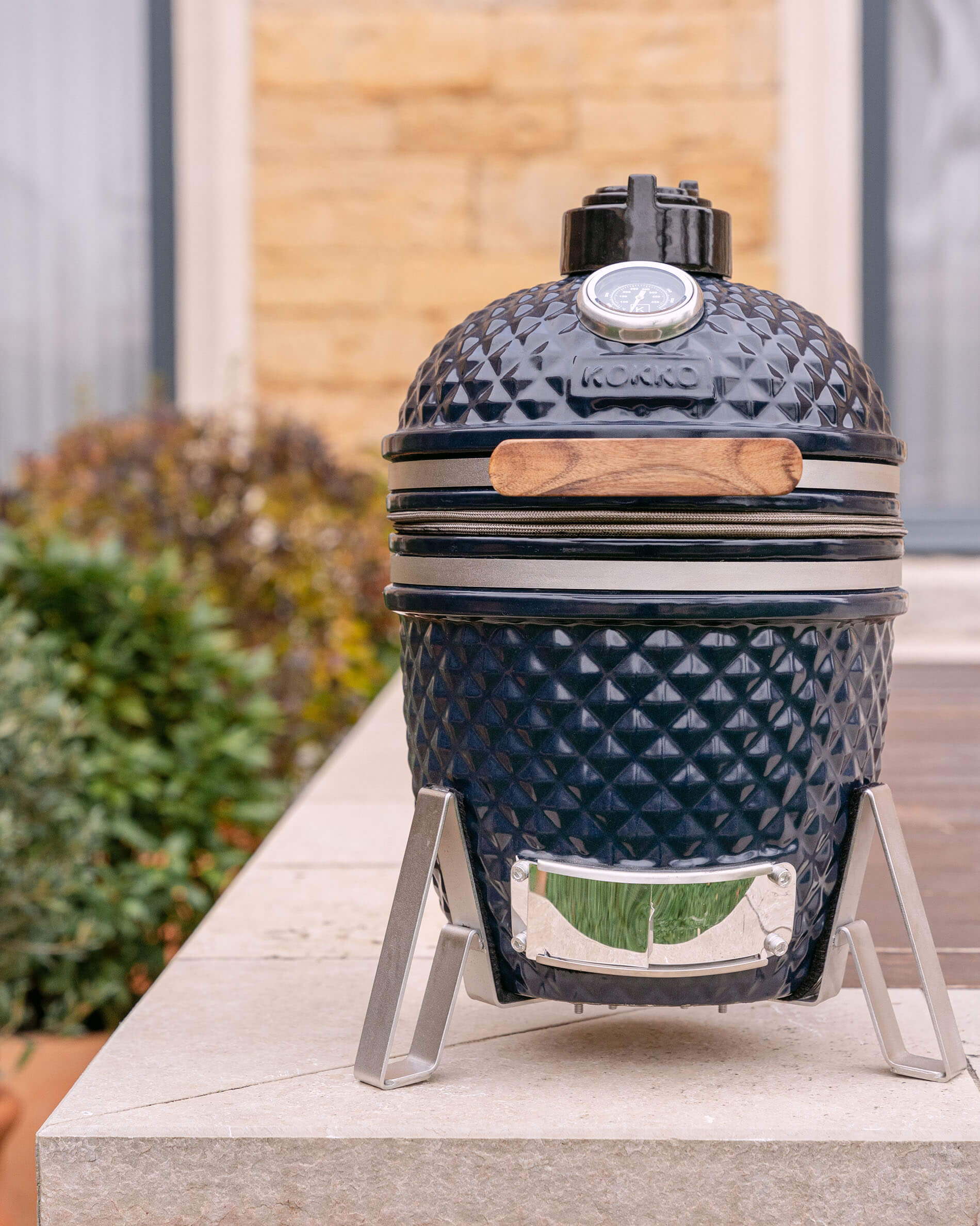 Kamado Little Kokko 13 em cerâmica azul-marinho colocado no seu suporte.