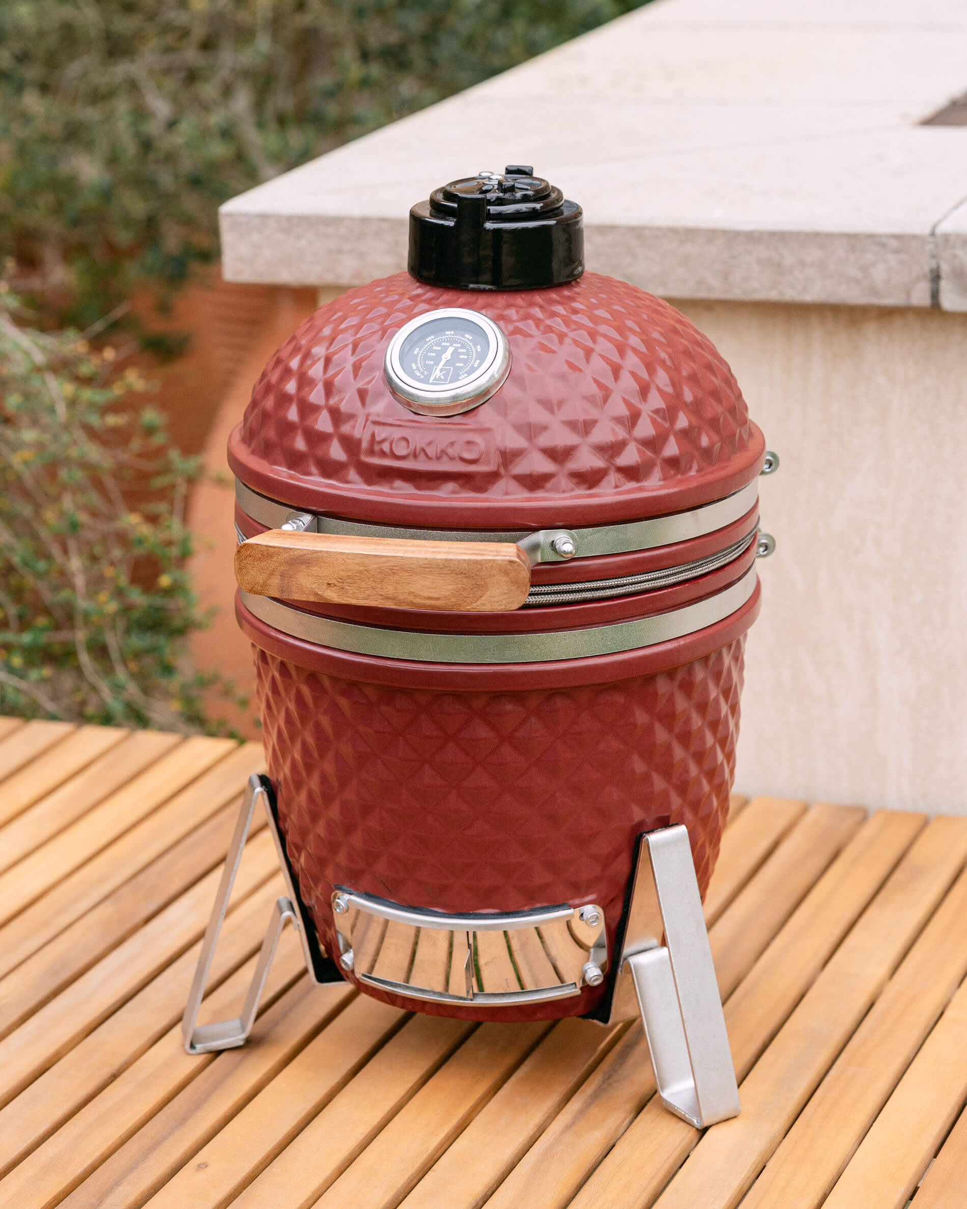 Kamado Little Kokko 13 vermelho óxido instalado num terraço.