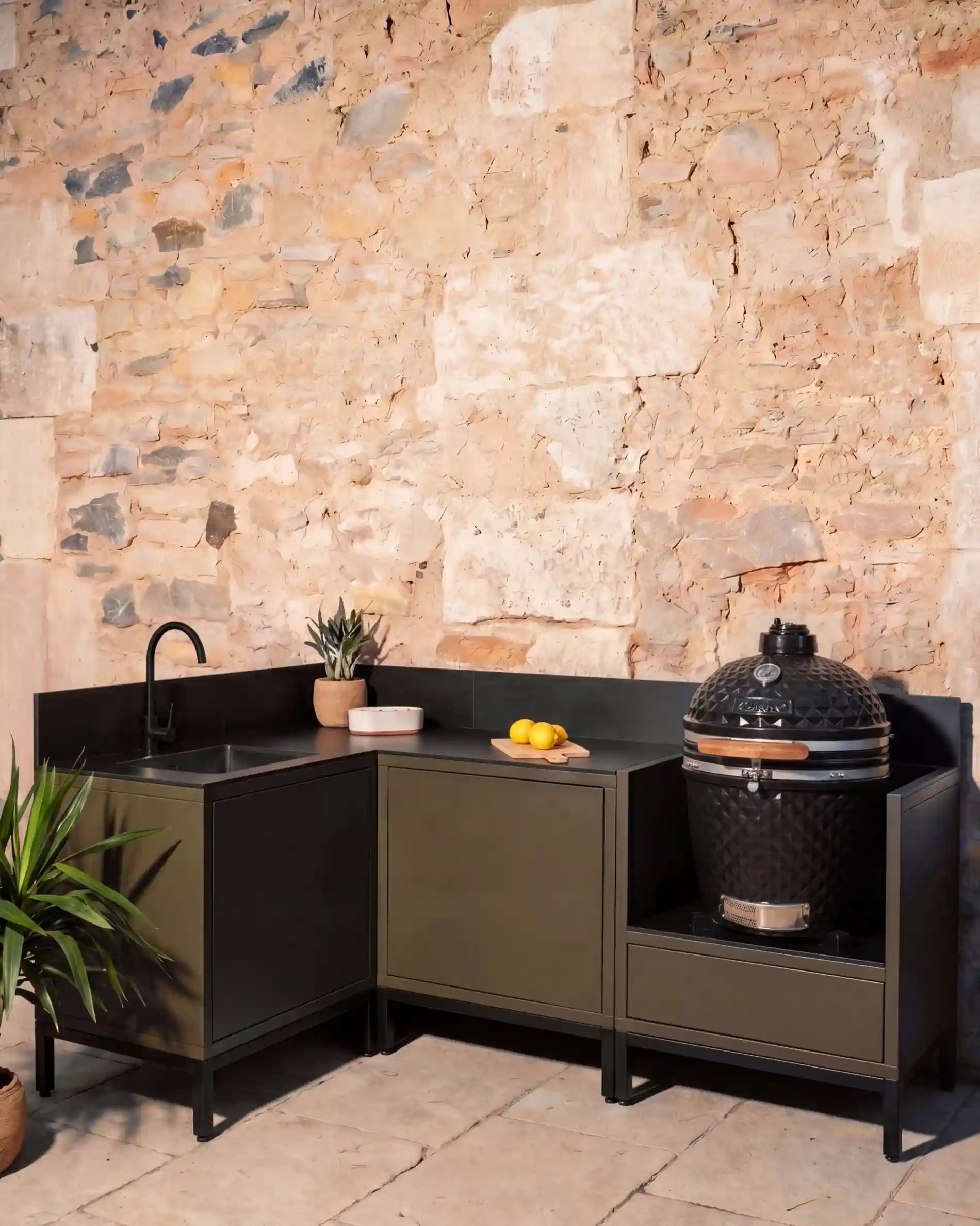 Cozinha exterior Kokko olive em ângulo com lava-loiça preto e kamado