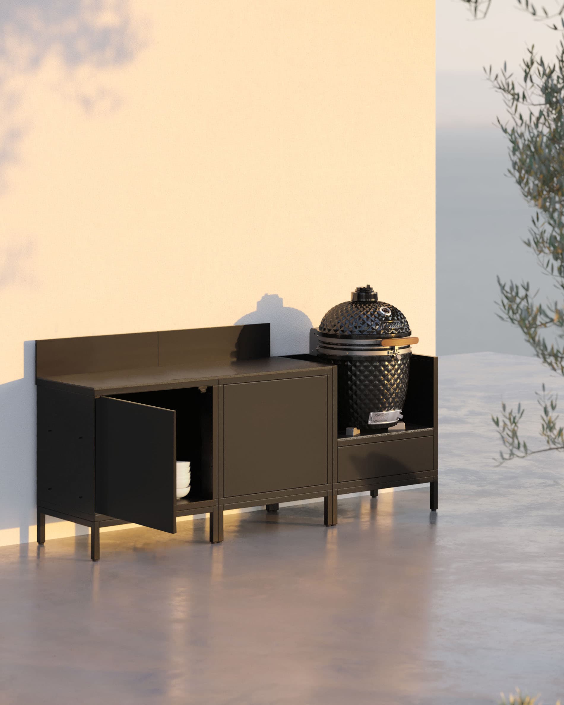 Cozinha pilotis com 3 módulos, kamado, móvel preto e uma porta de arrumação aberta.