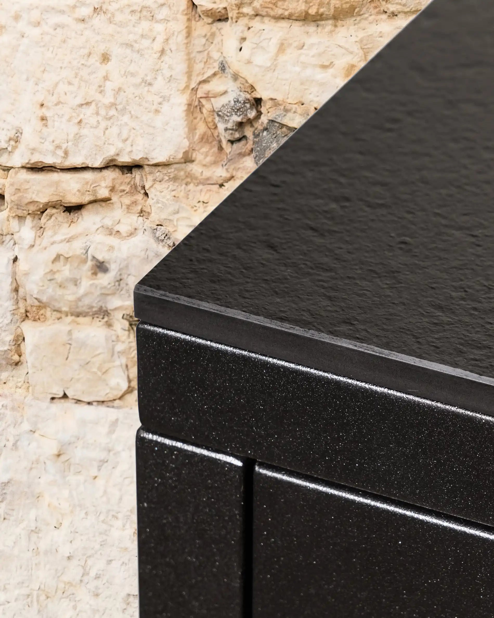 Detalhe do tampo de trabalho preto texturado da cozinha exterior Kokko