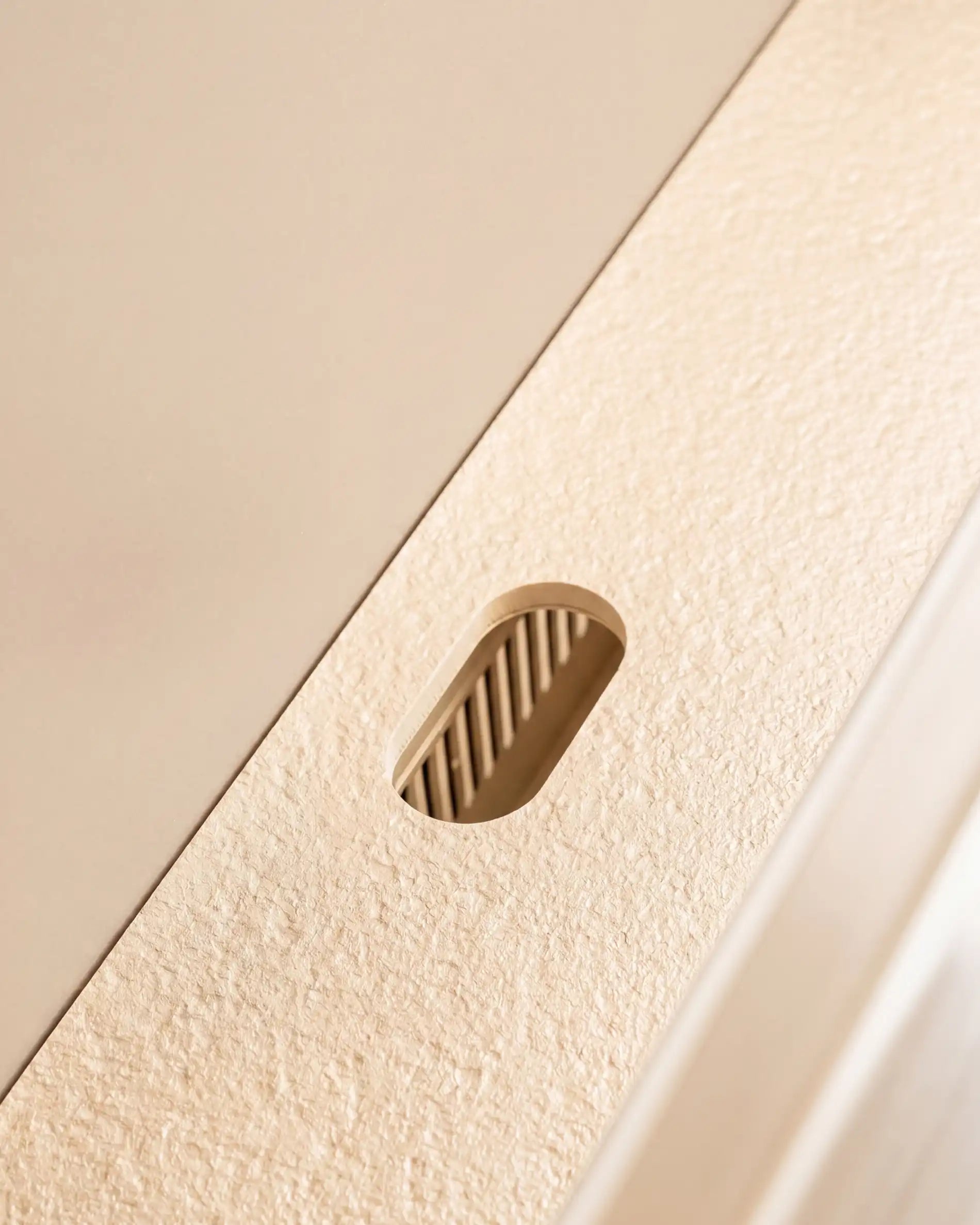 Detalhe da passagem de cabos no tampo da cozinha exterior Kokko creme